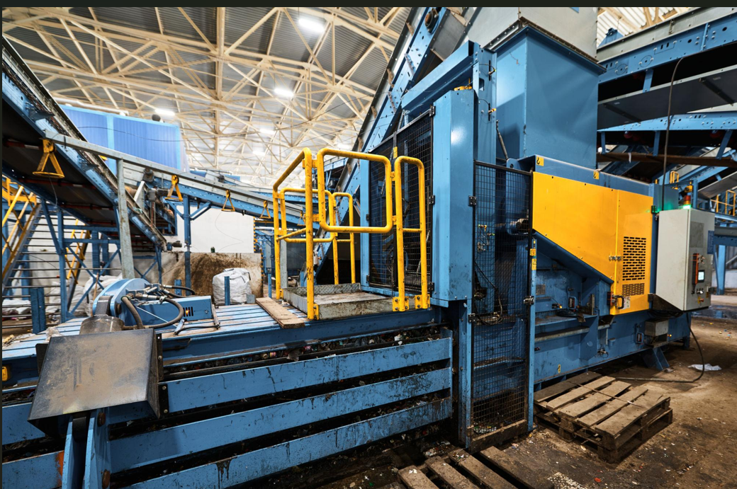 baler_machine_recycling_system_compressing_waste_into_dense_cardboard_and_plastic_bales_in_warehouse.png